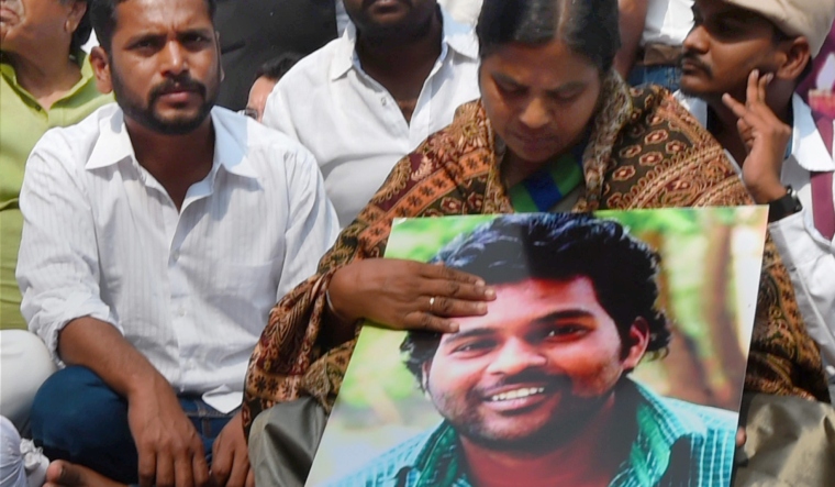 Rohith Vemula's mother Radhika Vemula holds his photo at a protest site. | PTI